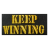 A black patch with gold writing that says " keep winning ".
