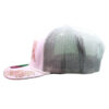 A white hat with a pink flower on it