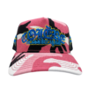 A pink and black hat with graffiti on it.
