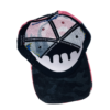 A black and pink hat with a face on it