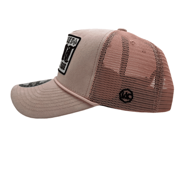 A pink and white hat with a black patch on it