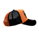 A black and orange hat is on top of the ground.