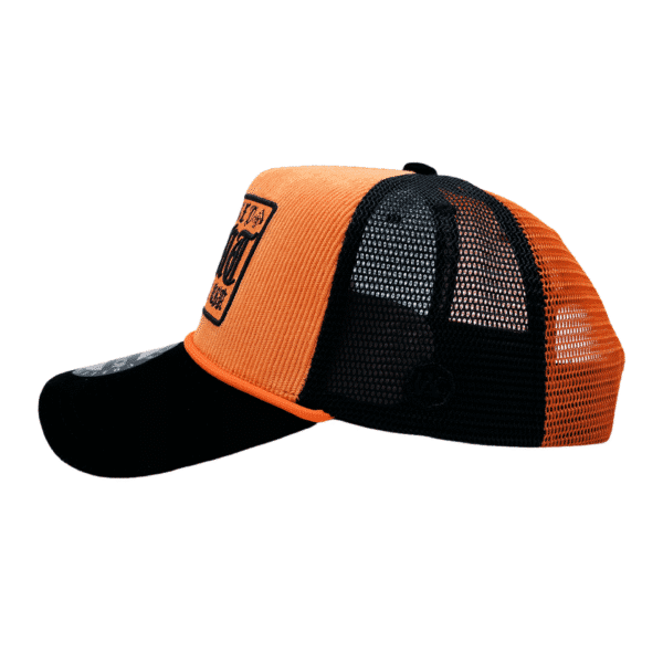 A black and orange hat is on the ground
