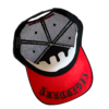 A red and black hat with a design on it.